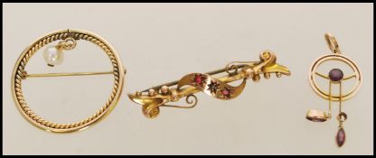 A early 20th century hallmarked 9ct gold bar brooch with scrolled decoration with inlaid red and