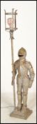 A mid century retro floorstanding cast and silvered metal standard lamp in the form of a knight in