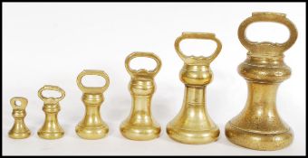 A selection of 20th century graduating brass bell weights with the largest being marked GR