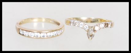 Two hallmarked 9ct gold rings to include channel inset CZ (size O) and a 9ct gold wishbone ring with