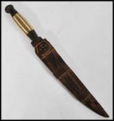 A 19th century bone handles bronze dagger complete in leather hide sheaf.