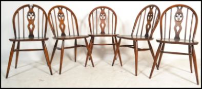 A set of 5 20th century retro Ercol beech and elm wood Windsor pattern dining chairs having hoop