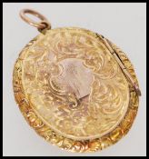 A Victorian 9ct gold ladies forget me not lovehearts locket having rococo chasing and plain