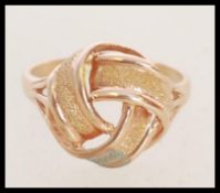 A vintage stamped 9ct rose gold ring with a knot design head. Weight 2.2g. Size N.
