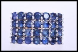 A silver white metal ring stamped 325 with a head of prong set blue stones. Weight approx 5g. Size