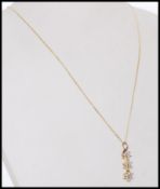 A stamped 750 18ct gold pendant necklace with a pendant having diamond stones set into three