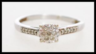 A 20th century 9ct white gold cluster ring having 17 illusion set 1pts diamonds within the crown and