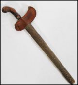 An antique Kris sword with an eared wooden handle and serpentine blade and scabbard. Measures 50