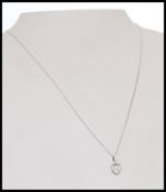 A hallmarked 18k white gold and diamond pendant necklace strung with a heart shaped pendant with