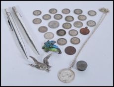 A collection of silver items to include silver coin pendant and chain, silver and enamel frog