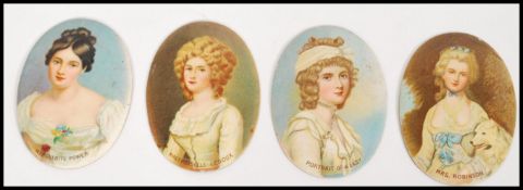 A set of four early 20th century enamelled printed portraits of women on metal oval form discs to