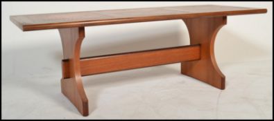 A retro 20th Century G plan coffee table with a three sectional inset hammered copper effect top,