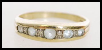 A hallmarked 9ct gold ring having channel set pale blue stones with accent diamonds. Hallmarked