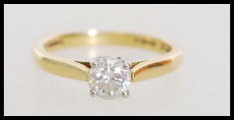 A hallmarked 18ct gold solitaire ring set with a central brilliant cut diamond. Diamond approx