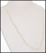 A 20th century graduated cultured pearl necklace with a decorative oval form clasp. Length 50cm.