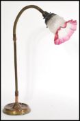 A 20th century Art Deco style goose neck desk lamp on a round base with a cranberry and frosted