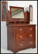 An Edwardian walnut batwing dressing table chest raised on plinth base with triple swing mirrors