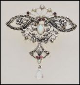 A stamped 925 silver brooch in the Art Nouveau style with inset red stones and pearls, having one