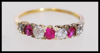 A stamped 18ct gold 7 stone ring set with old cut diamonds and rubies. Marked 18ct tests 18ct