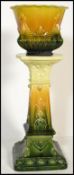 A 19th century Victorian pottery Jardiniere and stand having a green glaze with stylized