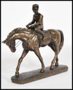 A 20th Century bronzed sculptural figural group modelled as a Jockey and race horse,set upon a