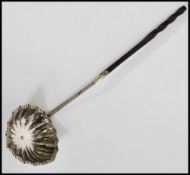 A 19th century Georgian toddy spoon / punch ladle with a twisted whale bone handle and a fluted