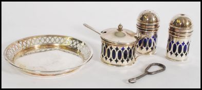 An early 20th century silver hallmarked cruet set with tray, to include three silver condiments with