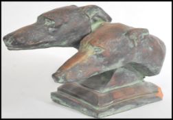 A carved 20th century / contemporary bronzed study / sculpture of greyhounds raised on a plinth