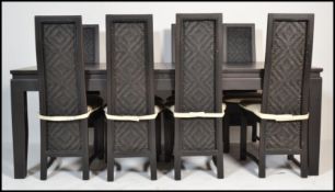A 20th Century large hardwood Chinese dining table and chairs, the large ebonised table raised on