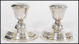 A pair of silver hallmarked stub candlesticks by Joseph Gloster Ltd raised on stepped circular bases