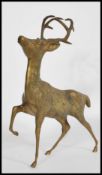 A large 20th century cast brass figurine of a stag. The detailed figure modelled with front leg