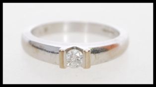 A hallmarked 20th century 18ct white gold and diamond ring having a tension solitaire diamond of