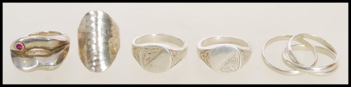 A selection of silver rings to include signet rings with Celtic knot engraving, a hammered fashion