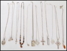 A selection of silver necklaces to include an elephant pendant, an engraved oval locket and crucifix