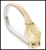 A 20th century Omega Geneve ladies cocktail watch having an oval face and stick markings in a gold