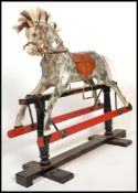 A vintage early 20th century Edwardian rocking horse raised on wooden rocking base with painted