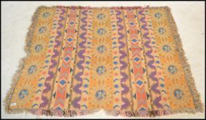 A retro Welsh woollen blanket of decorative form having tassled ends. Yellow colourway with