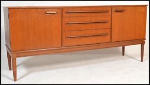 A vintage retro 20th century teak wood Danish inspired sideboard having a central bank of three