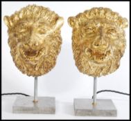 A pair of 20th century carved wood gilded lion head lamps with on modern square metal bases.