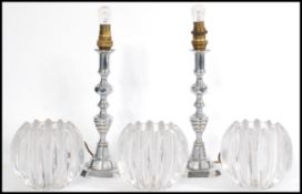 A pair of vintage 20th century chrome candlesticks having faceted glass bulbous shades. Measures