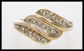 A 9ct gold and diamond ring with 17 1pt diamonds in an illusion setting styled in a wave design.