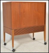 A 1970's teak wood tambour fronted Danish influence entertainment cabinet raised on squared legs
