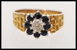 A hallmarked 9ct gold retro sapphire and diamond cluster ring having brick work engraving to the
