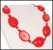 A contemporary large baroque coral necklace having nine graduating coral cabochons with coral and