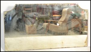 A large 19th century Victorian Industrial shop mirror glass of arched form having foxed and pitted