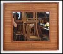 A retro 20th Century teak framed wall mirror, the central mirror panel surrounded with bamboo cane