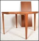 A mid century Danish teak wood circular extending dining table of circular form being raised on