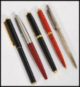 A selection of writing pens to include two Parker pens, one being a nibbed fountain pen, two other