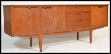 A 1970's retro teak wood sideboard credenza of Danish influence raised on tapering legs with a