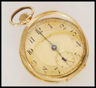 An Initiative stamped 18k gold pocket watch with a yellow metal face having Arabic numerals to the